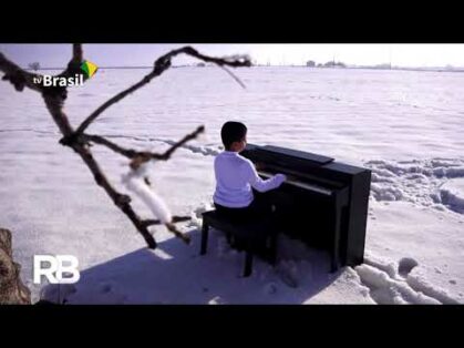 Menino realiza sonho de tocar piano na neve